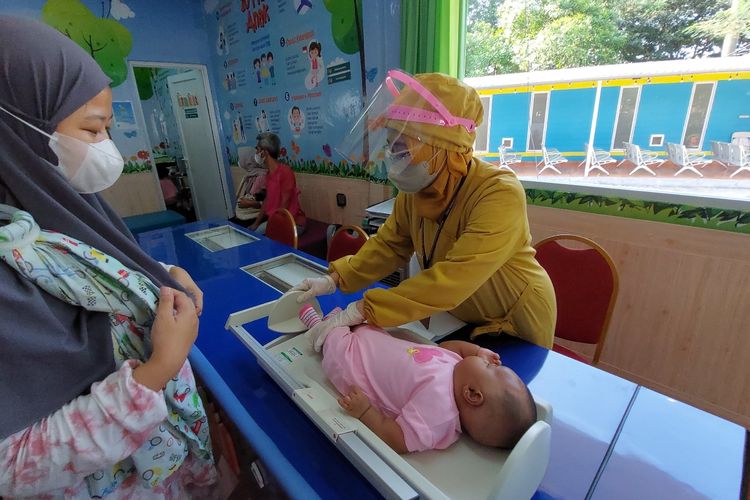 Tenaga Kesehatan Puskesmas Kembangan menimbang bayi sebelum dilakukan imunisasi Pneumococcal Conjugate Vaccine (PCV) di Puskesmas Kembangan, Jakarta Barat, Senin (12/9/2022).