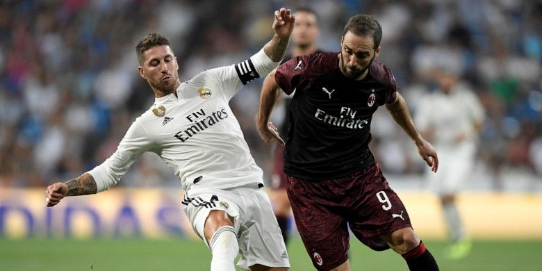 Penyerang AC Milan, Gonzalo Higuain (kanan), berduel dengan bek Real Madrid, Sergio Ramos, dalam laga Trofeo Santiago Bernabeu di Stadion Santiago Bernabeu, Madrid, Spanyol pada 11 Agustus 2018.
