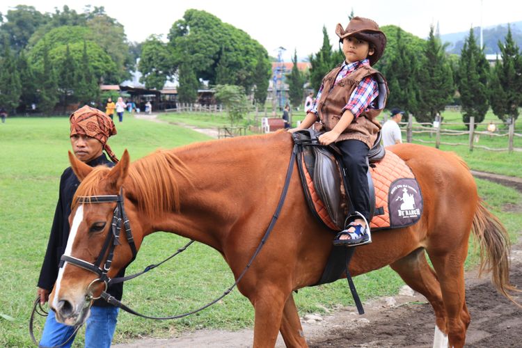 Seorang anak naik kuda di De'Ranch Lembang. De'Ranch adalah salah satu tempat wisata Lembang yang bisa dikunjungi.