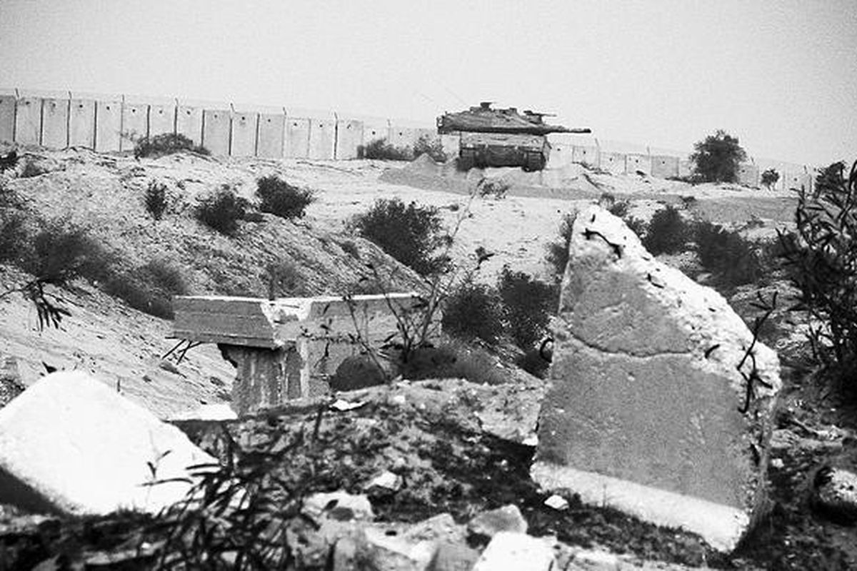 Sebuah tank Israel terlihat di dekat perbatasan di bagian utara Jalur Gaza, Sabtu (26/12). Setahun setelah invasi Israel ke Gaza, kekerasan masih terlihat. Seperti terjadi Sabtu kemarin, serangan udara Israel menewaskan tiga warga Palestina, tak jauh dari garis pemisah perbatasan Israel ini.