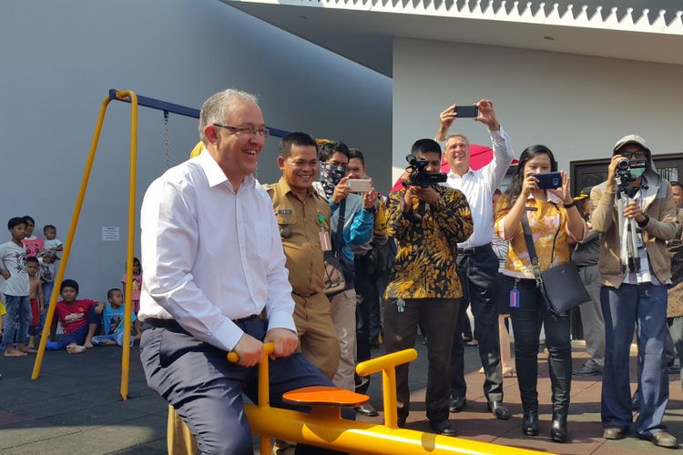 Wali Kota Rotterdam, Belanda, Ahmed Aboutaleb, menjajal wahana permainan anak jungkat-jungkit di RPTRA Kalijodo, Senin (12/6/2017).