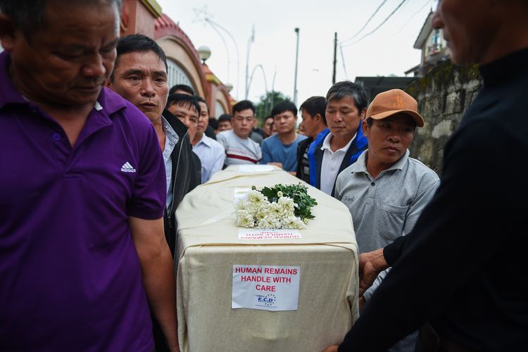 Kerabat membawa peti berisi jenazah Nguyen Van Hung ketika dia tiba di distrik Dien Chau, Provinsi Nghe An, Vietnam, pada 27 November 2019. Nguyen merupakan satu dari 39 mayat yang ditemukan dalam kontainer di Inggris 23 Oktober lalu. Dia merupakan gelombang pertama jenazah yang diterbangkan dari London ke Hanoi.