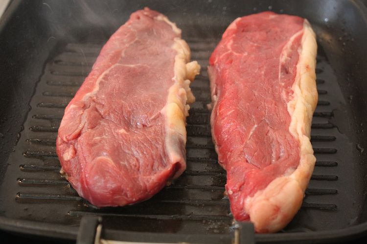 Ilustrasi memangang daging steak 