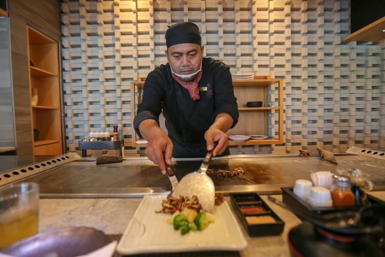 Chef menyajikan makanan yang baru dimasak di atas plat besi di Restoran Maison Tatsuya Teppanyaki, Kebon Sirih, Jakarta, Rabu (11/03/2020). Restoran ini menawarkan pengalaman makan dengan menyantap langsung makanan yang dimasak di depan pengunjung.