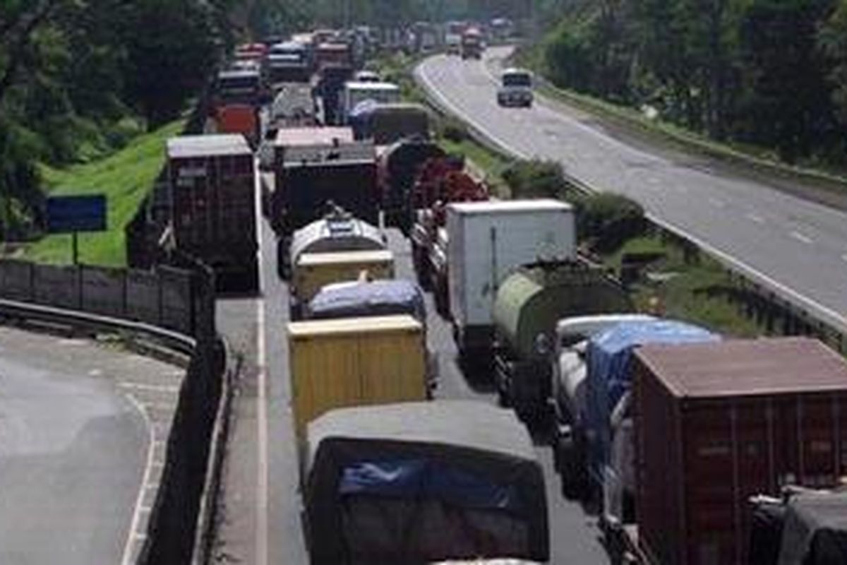 Mobil terjebak macet tol Jakarta-Merak di Balaraja Timur, Serang, Banten, akibat banjir luapan Sungai Ciujung yang merendam tol di kilometer 57, Kamis (10/1/2013). Akibat banjir ini akses tol Jakarta-Merak putus dan ratusan rumah warga terendam. KOMPAS IMAGES/KRISTIANTO PURNOMO