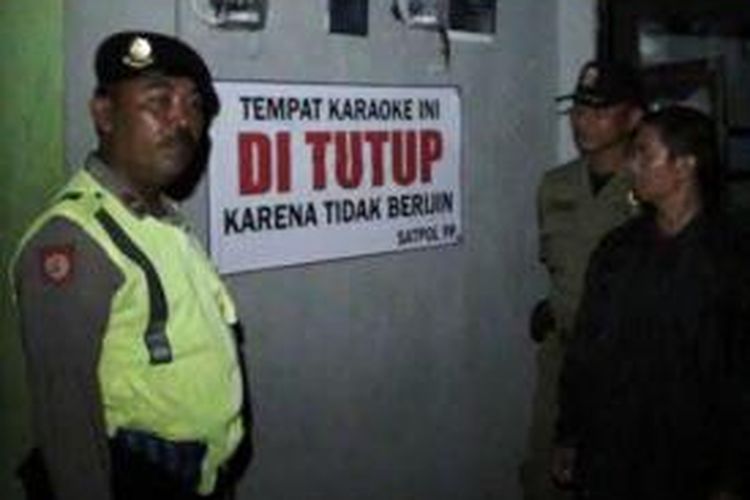 Petugas memasang tulisan tempat karoeke di tutup karena tidak berijin Kamis (28/11/2013)