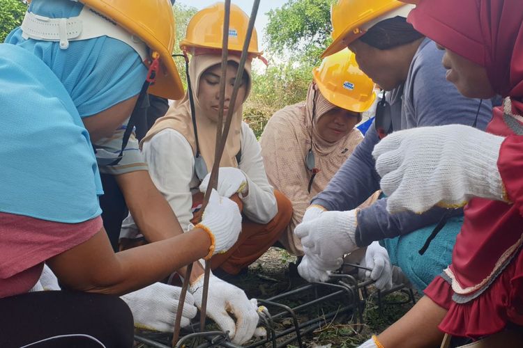 Hairunisa (baju putih) bersama sejumlah Ibu di desa Beka, Marawola, Kabupaten Sigi, Sulawesi Tengah mempraktekkan cara mengikat batang-batang besi yang digunakan untuk kebutuhan tiang bangunan rumah, 7 Desember 2019. 