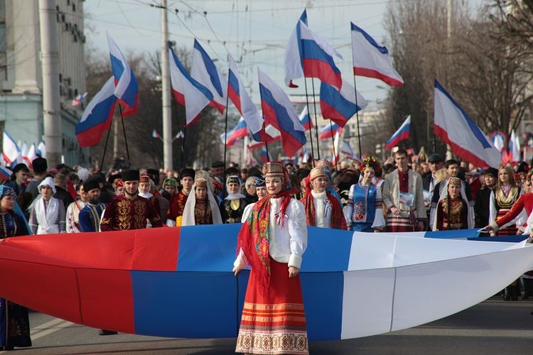 Warga kota Simferopol, Crimea membawa bendera Rusia saat merayakan lima tahun bergabungnya kembali semenanjung itu dengan Rusia.