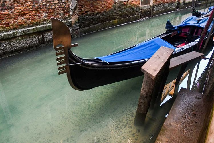 A view shows clearer waters by a gondola in a Venice canal on March 17, 2020 as a result of the stoppage of motorboat traffic, following the countrys lockdown within the new coronavirus crisis. (Photo by ANDREA PATTARO / AFP) (Photo by ANDREA PATTARO/AFP via Getty Images)