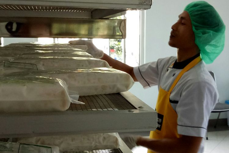 Budi (31) sedang menata tempe yang sudah selesai masa fermentasi, dan siap jual di Rumah Tempe Indonesia, Bogor, Selasa (23/5/2017).