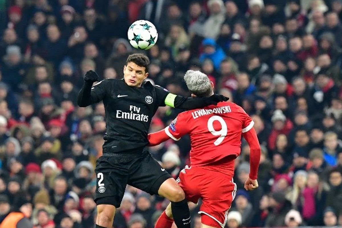Pemain depan Bayern Munich Robert Lewandowski (kanan) menyundul bola dengan bek Brasil Paris Saint-Germain Thiago Silva selama pertandingan sepak bola Liga Champions UEFA Bayern Munich vs Paris Saint-Germain pada 5 Desember 2017 di Munich, Jerman selatan.