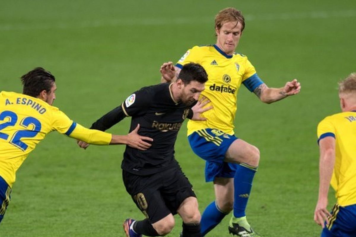 Bek Cadiz asal Uruguay Luis Espino ?Pacha? (Kiri), gelandang Spanyol Alex Fernandez (2R) dan gelandang Belanda Jens Jonsson (kanan) menantang penyerang Barcelona asal Argentina Lionel Messi selama pertandingan sepak bola Liga Spanyol antara Cadiz dan Barcelona di stadion Ramon de Carranza di Cadiz pada 5 Desember 2020.
