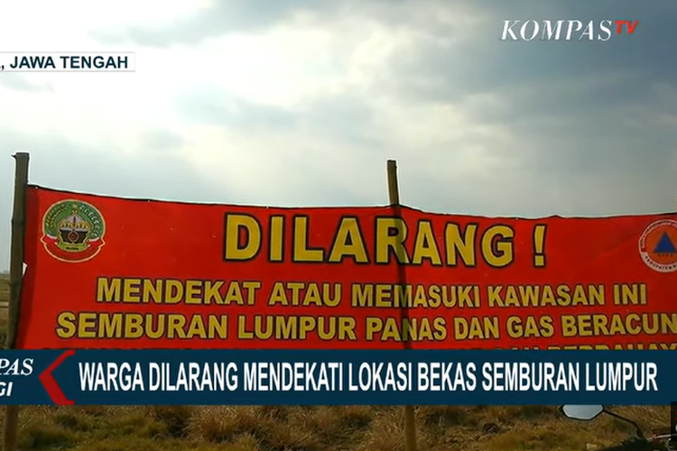 Spanduk bertuliskan peringatan kepada warga di lokasi semburan lumpur panas di Kesongo, Blora.
