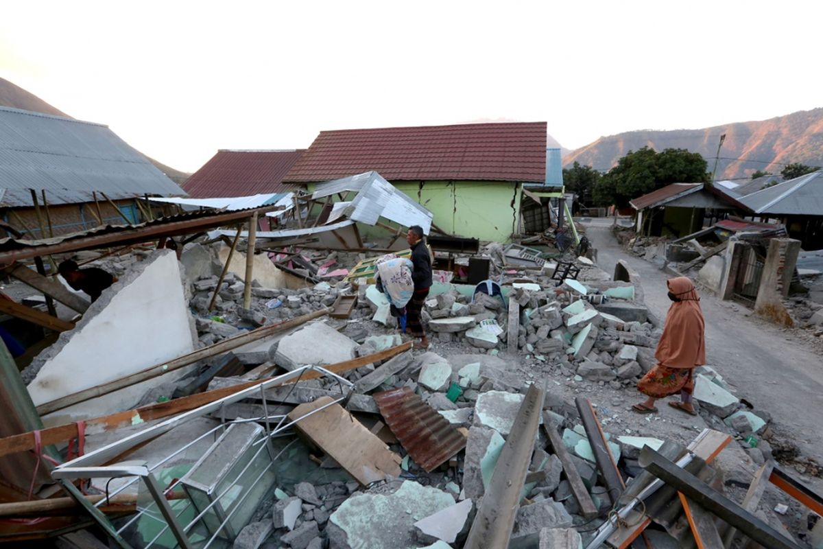 Warga memeriksa rumah mereka yang roboh di desa Sembalun, pulau Lombok pada 20 Agustus 2018 setelah serangkaian gempa bumi dicatat oleh seismolog sepanjang 19 Agustus. Menurut laporan pihak berwenang pada Senin (20/8/2018), setidaknya 10 orang tewas setelah serangkaian gempa kuat mengguncang pulau Lombok. Ini merupakan gempa baru yang berbeda dari gempa berkekuatan M 7,0 pada Minggu (5/8/2018) yang telah menewaskan ratusan nyawa dan ribuan orang kehilangan tempat tinggal.