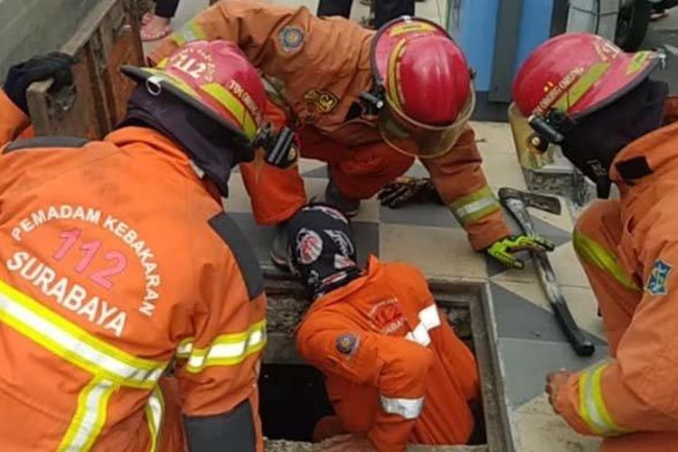 Sejumlah petugas pemadam kebakaran (Damkar) Kota Surabaya menyelamatkan seekor anak kucing terjebak saluran air di kawasan Balai Pemuda Surabaya, Jumat sore (10/9/2021). 
