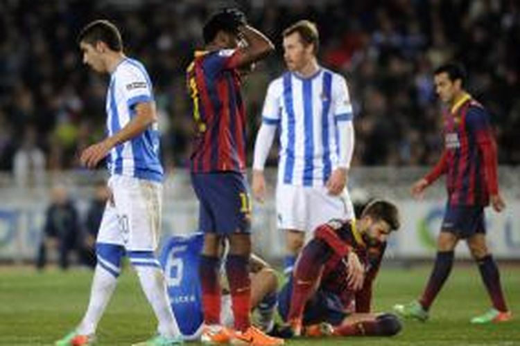 Bek Barcelona Gerard Pique  (kedua dari kiri) terjatuh di tengah-tengah pertandingan La Liga melawan Real Sociedad, di Anoeta, Sabtu (22/2/2014).