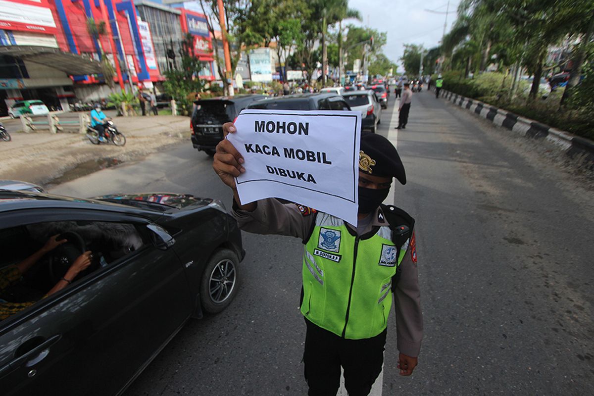 Polisi memeriksa kendaraan bermotor saat hari pertama Pembatasan Sosial Berskala Besar (PSBB) di perbatasan Kota Banjarmasin, Kalimantan Selatan, Jumat (24/4/2020). Pemerintah Kota Banjarmasin resmi menerapkan PSBB dalam rangka percepatan penangan COVID-19 selama 14 hari dimulai 24 April hingga 7 Mei 2020.