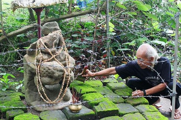 Yudi (72), penjaga situs Semen di Kecamatan Pagu, Kabupaten Kediri, Jawa Timur, membersihkan debu yang menempel di arca Garuda Wisnu Kencana, Rabu (11/2/2015). Situs pemandian raja dari Kerajaan Kediri yang ditemukan tahun 1999 itu menjadi salah satu tujuan wisata minat khusus.
