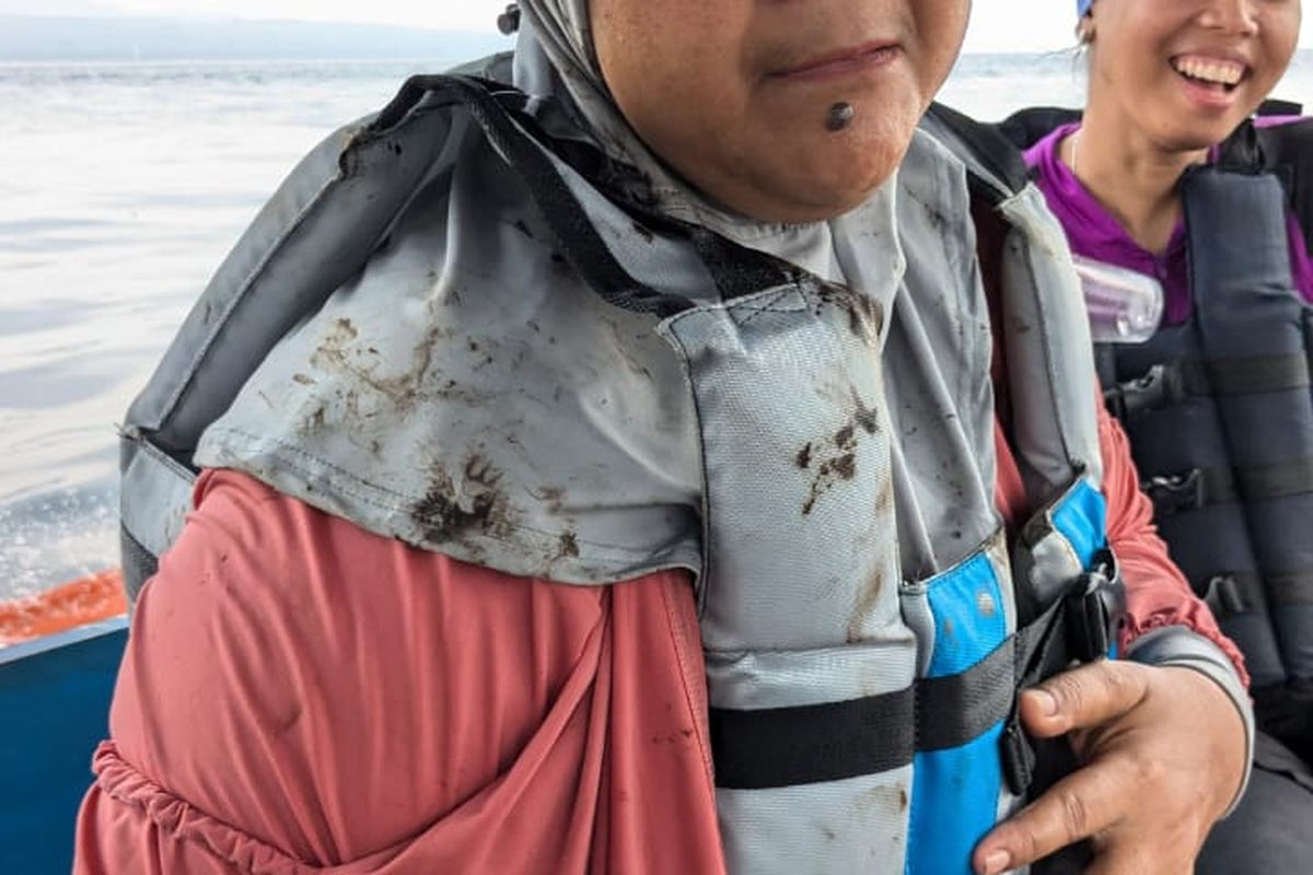 wisatawan berlumuran oli karena pencemaran di Pantai Bangsring Banyuwangi, Rabu (19/2/2025) 