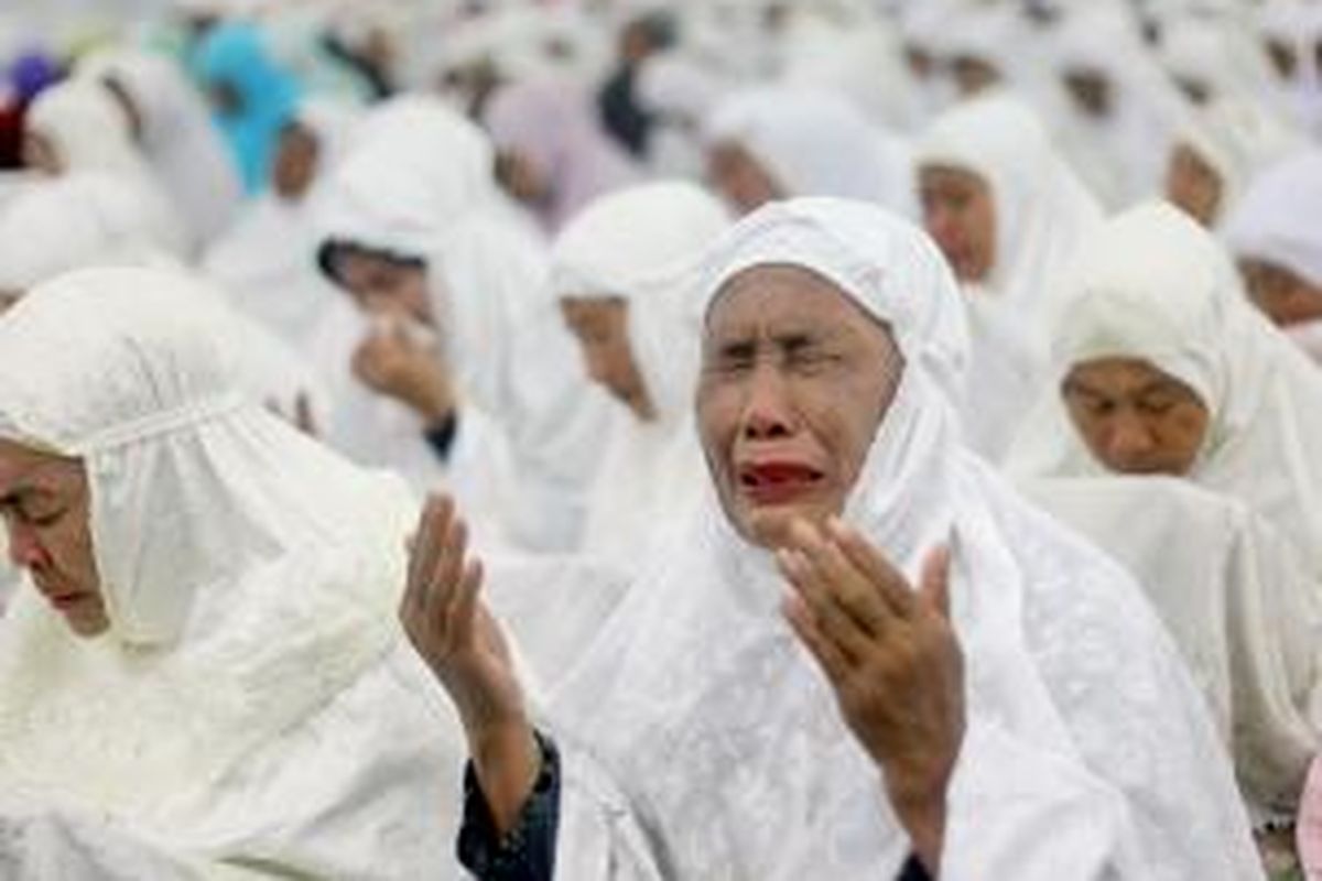 Seorang perempuan berdoa dengan kesedihan tanpa air mata, dalam Aceh Berzikir, kegiatan doa bersama yang digelar sebagai bagian peringatan 10 tahun tsunami Aceh di masjid Baiturrahman, Banda Aceh, Nanggroe Aceh Darussalam, Kamis (25/12/2014) malam.