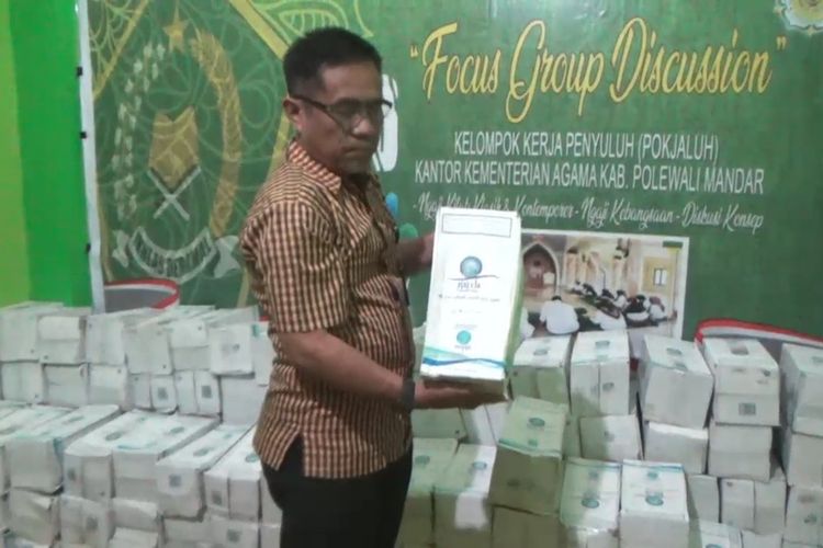 Seorang petugas di Kantor Kementerian Agama Polewali Mandar, Sulawesi Barat, menunjukkna botol kiriman air zamzam dari jemaah yang melaksanakan ibadah hai di Mekkah, Arab Saudi.