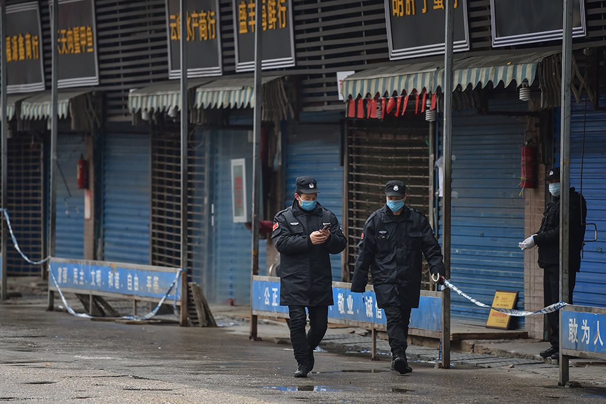 Petugas keamanan berpatroli di pasar ikan tradisional Huanan di kota Wuhan, China, Jumat (24/1/2020). Pasar ikan itu ditutup setelah virus corona yang mematikan dideteksi berasal dari pasar itu.