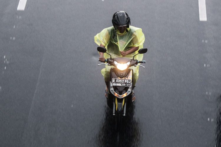 Pengendara sepeda motor mengenakan jas hujan saat terjadi hujan di Jalan Ir. H. Juanda, Gambir, Jakarta Pusat, Minggu (22/12/2019). Badan Meteorologi, Klimatologi, dan Geofisika (BMKG) memberikan informasi dini cuaca ektrem yang akan melanda sejumlah wilayah di Indonesia pada hari Minggu (22/12/2019), dan Senin (23/12/2019).