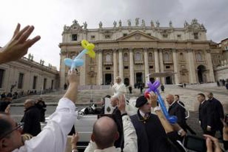 Paus Fransiskus membalas sapaan umat saat dia meninggalkan Alun-alun St Peter usai pertemuan umum mingguan di Vatikan, 9 Oktober 2013.