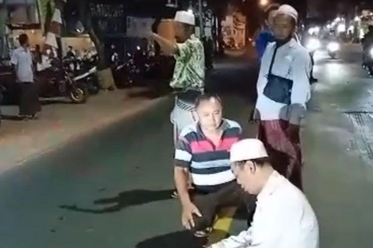 Tangkapan video pria paruh baya menunaikan salat di tengah Jalan Raya Sembayat, Kecamatan Manyar, Gresik, Jawa Timur.