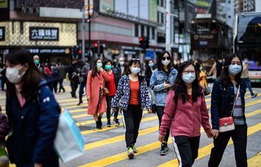 Pengguna jalan mengenakan masker melintas di jalanan Hong Kong di tengah masa liburan Tahun Baru Imlek pada 27 Januari 2020. Saat ini, China tengah dihantam virus corona yang sudah membunuh lebih dari 100 orang.