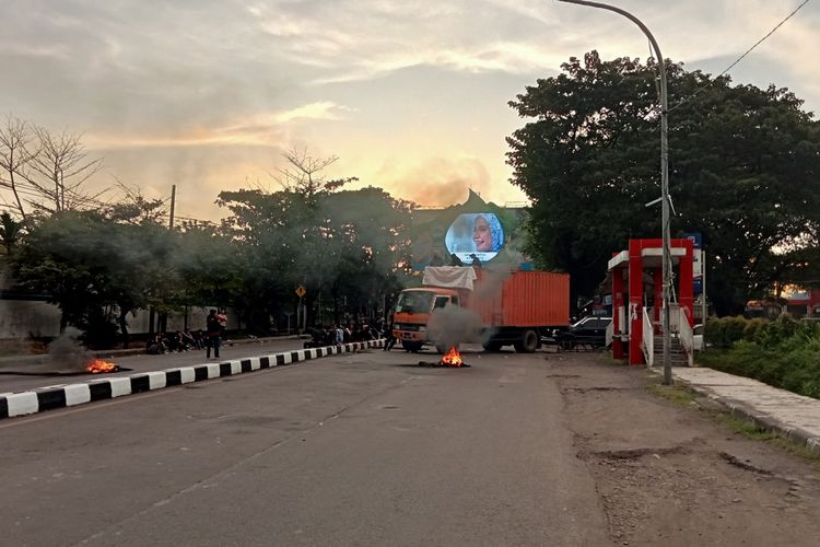 Kondisi Jalan Sultan Alauddin, Kota Makassar, Sulawesi Selatan (Sulsel), yang diblokade mahasiswa menggunakan truk kontainer dan ban bekas hingga mengakibatkan macet parah. Selasa (2/5/2023)