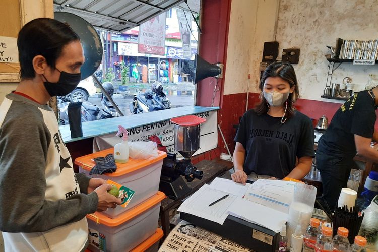 Sejumlah pembeli di Kedai Kopi Klodjen Djaja Kota Malang saat membeli kopi secara gratis dengan menunjukkan sertifikat vaksin, Jumat (30/7/2021).