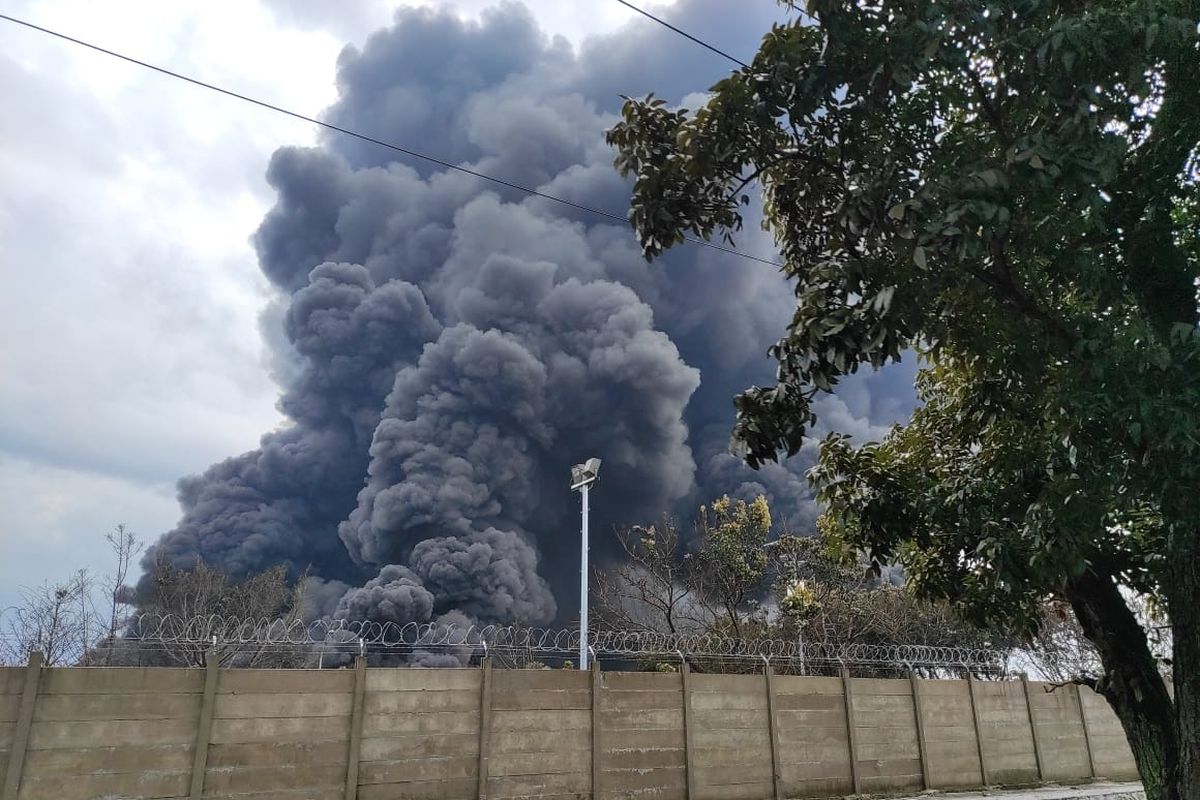 Asap hitam mengepul dari kebakaran tangki minyak T-130G milik PT Pertamina (Persero) RU VI Balongan Indramayu, Selasa (30/3/2021). Sebelum terbakar kilang ini meledak pada Senin (29/3/2021) kemarin malam diduga karena tersambar petir.