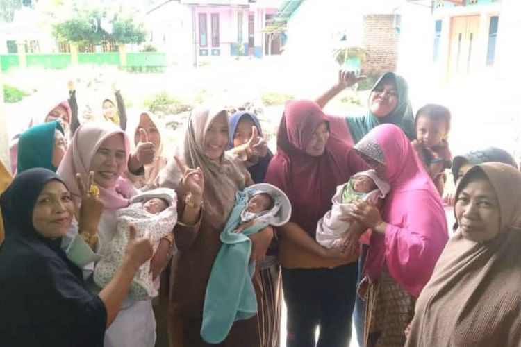 Warga saat menyambut kedatangan bayi perempuan kembar tiga pasutri Mawardi dan Saribanun di Desa Sawahmulya di Kecamatan Sangkapura Kepulauan Bawean, Gresik, Jawa Timur.