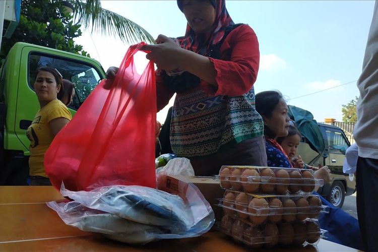 Seorang warga Rusunawa Tipar Cakung, Jakarta Timur tampak membereskan pangan murah, Selasa (18/6/2019).