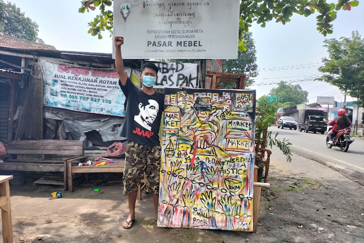 Pedagang Pasar Mebel generasi ke-3, Boby Sutanto (30) yang mengenakan baju bergambar Presiden Jokowi menjelaskan makna lukisan dari Seniman Solo menceritakan penolakan dan kebungkaman Wali Kota Gibran Rakabuming atas masalah Pasar Mebel.