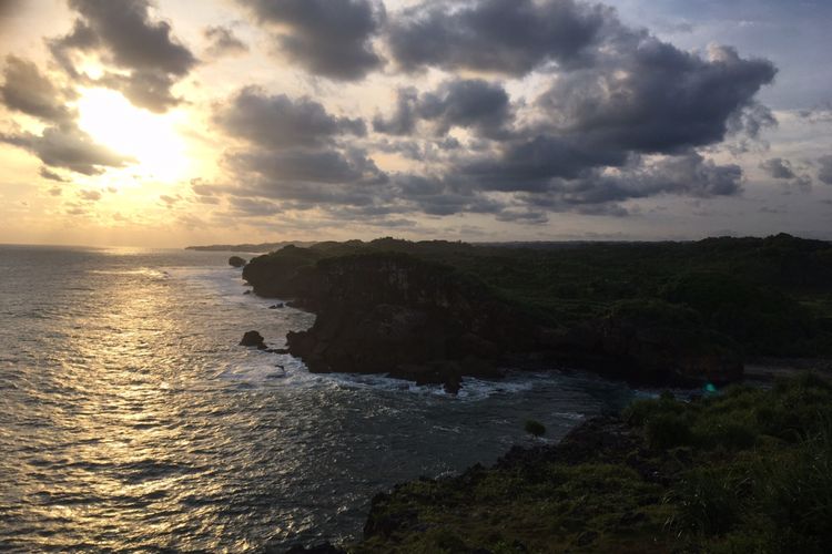 Pemandangan matahari terbenam dari atas bukit di Pantai Krakal