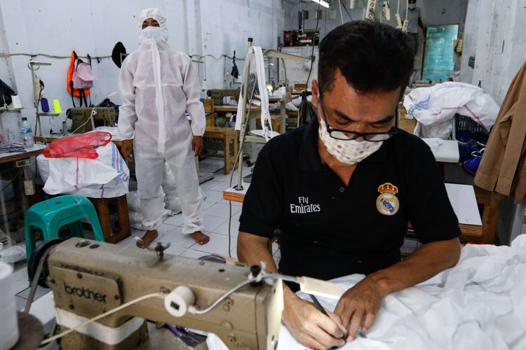 Pekerja menyelesaikan pembuatan alat pelindung diri di konveksi milik Riswan Halomoan di kawasan PIK, Penggilingan, Jakarta Timur, Kamis (26/3/2020). Konveksi ini memproduksi 1000 APD perhari pesanan dari berbagai rumah sakit untuk tenaga medis yang menangani pasien COVID-19.