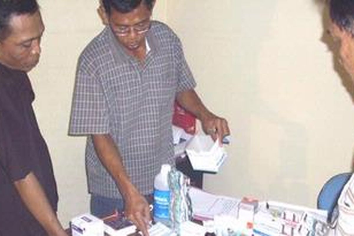 Abdul Hadi, tersangka dokter palsu sedang menjelaskan jenis obat yang disita polisi.  