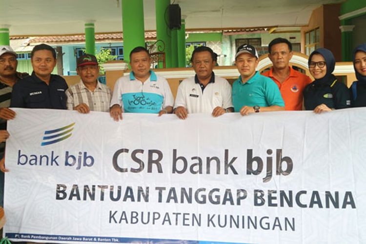 Kepala bank bjb Cabang Kuningan, Maman Rukmana disaksikan Plt Bupati Kuningan Dede Sembada, Kepala Badan Penanggulangan Bencana Daerah (BPBD) Agus Mauludin saat penyerahan bantuan untuk korban banjir dna longsor, pada Sabtu (3/3).