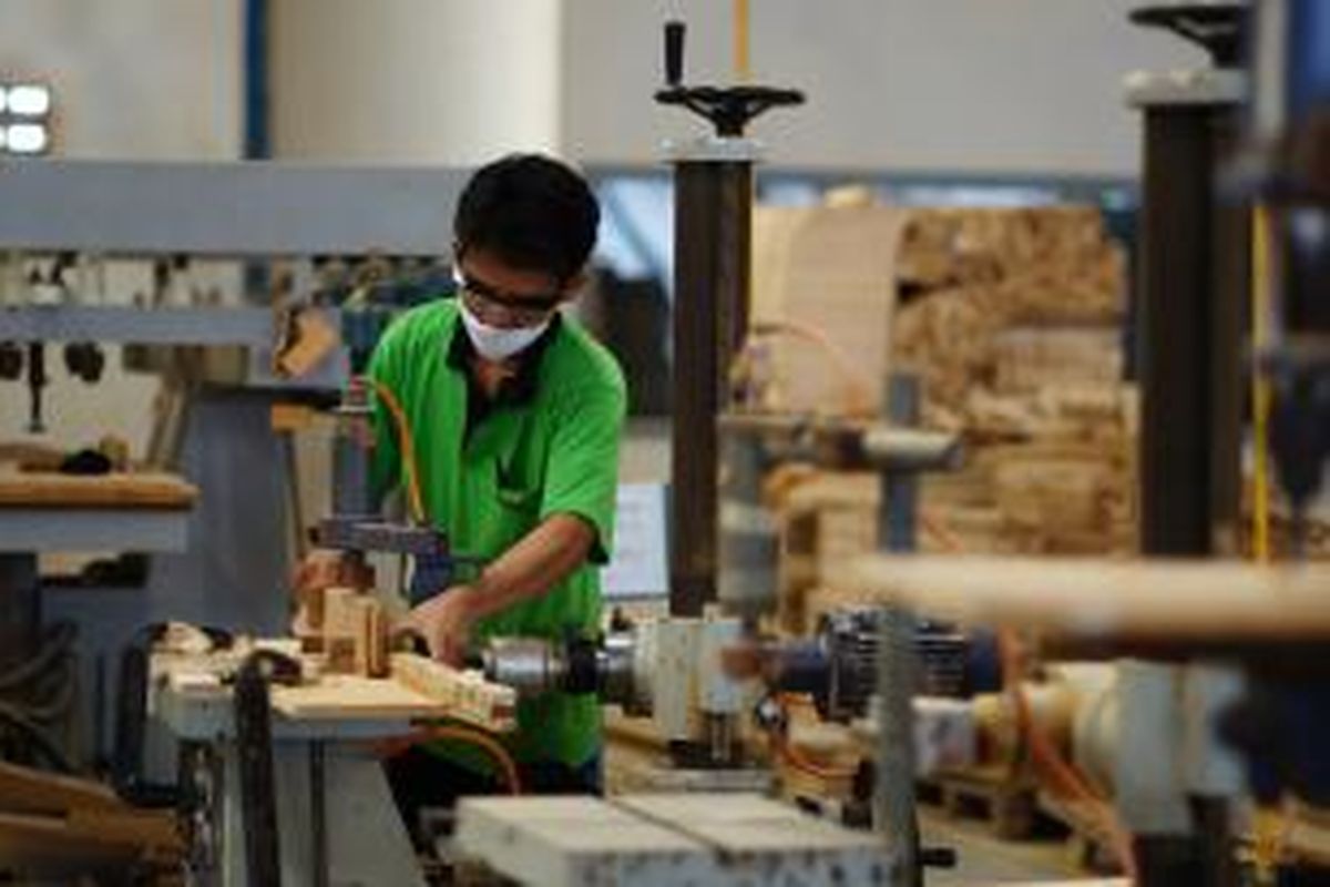 Ilustrasi: Salah seorang pekerja pabrik mebel tengah melubangi kayu jati dengan menggunakan horizontal bor.