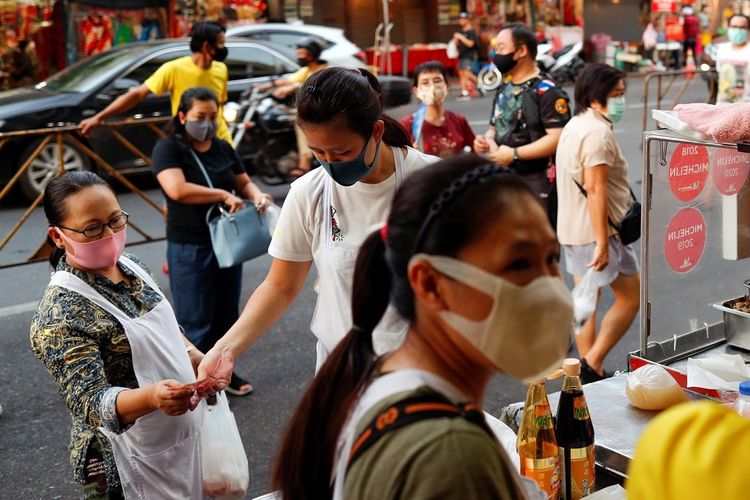 Para pedagang memakai masker pelindung menjual makanan di Chinatown, setelah pemerintah mulai membuka beberapa restoran di luar pusat perbelanjaan, tempat parkir, dan tukang cukur saat penyebaran penyakit virus korona (COVID-19) di Bangkok, Thailand, Minggu (3/5/2020). ANTARA FOTO/REUTERS/Jorge Silva/aww/cfo
