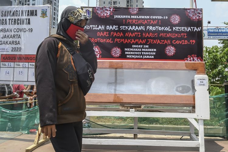 Warga melintas di depan peti mati berisi replika jenazah korban COVID-19 di kawasan Tanjung Barat, Jakarta, Sabtu (5/9/2020). Pemerintah terus berupaya melakukan kampanye peringatan bahaya COVID-19 bagi masyarakat guna menekan angka positif dan kematian akibat virus tersebut. ANTARA FOTO/Muhammad Adimaja/pras.