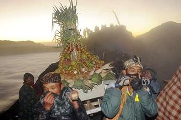 Warga suku Tengger membawa sesaji untuk dilarung ke kawah Gunung Bromo pada puncak upacara adat Kasada, di Kecamatan Sukapura, Kabupaten Probolinggo, Jawa Timur, Selasa (12/8/2014). Kegiatan yang berlangsung setahun sekali ini harus dilaksanakan meski bau belerang dari kawah gunung menyengat.