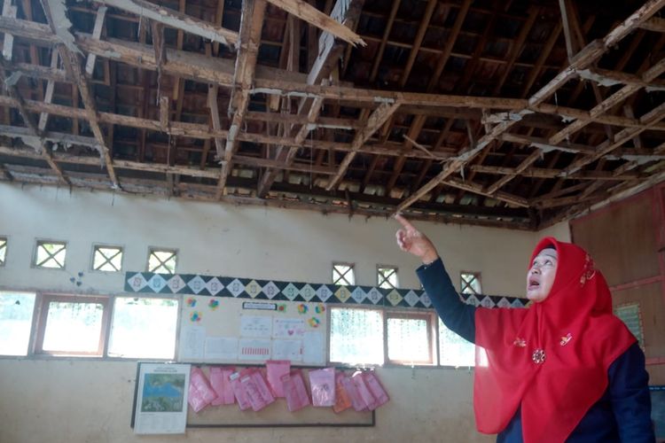 Seorang guru SDN Pancawangi Cilaku, Kabupaten Cianjur, Jawa Barat memerlihatkan kondisi salahsatu ruang kelas yang rusak berat akibat lapuk dimakan usia.
