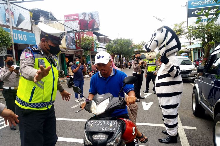 Satlantas Polres Blitar menghentikan pengguna jalan di Jalan Urip Sumoharjo, Kecamatan Wlingi, Kabupaten Blitar, Jumat (26/11/2021) dalam kampanye taat prokes dan vaksin Covid-19.