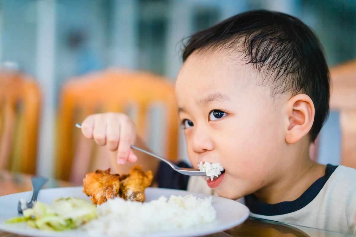 Ilustrasi anak makan dengan lahap. 