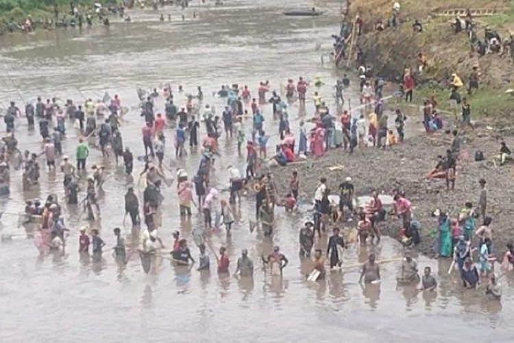 Warga berburu ikan dalam tradisi asatan di sepanjang aliran sungai Sampean Lama, Desa Kotakan, Kecamatan Situbondo.