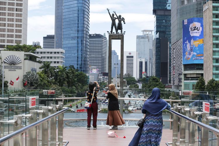 Pengunjung berfoto di anjungan Halte Transjakarta Bundaran Hotel Indonesia, Jakarta, Jumat (28/10/2022). Warga Ibu Kota datang ke halte yang belum sepenuhnya rampung itu untuk antre berfoto demi dapat latar belakang Patung Selamat Datang.