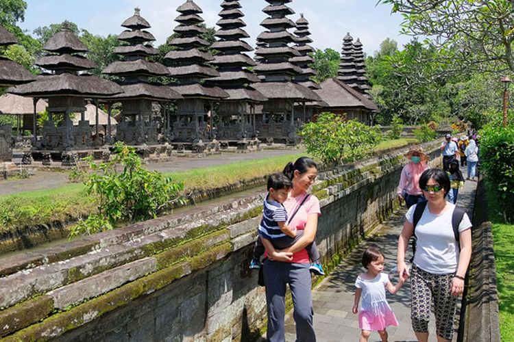 Wisatawan berjalan di kawasan Pura Taman Ayun, Badung, Bali, Jumat (14/12/2018). Wisatawan mancanegara yang datang ke Bali masih didominasi turis Cina yaitu mencapai 23,4 persen dari total wistawan yang berkunjung ke Pulau Dewata. 